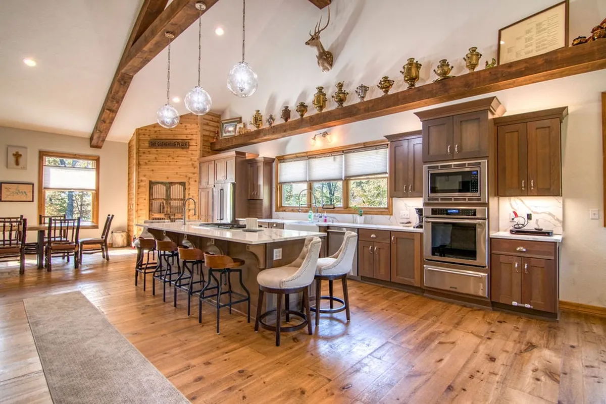 A cozy kitchen island bar with comfortable seating, set near large windows that allow ample natural light. The surrounding decor and open shelving contribute to a homely yet stylish atmosphere, ideal for both cooking and casual dining.